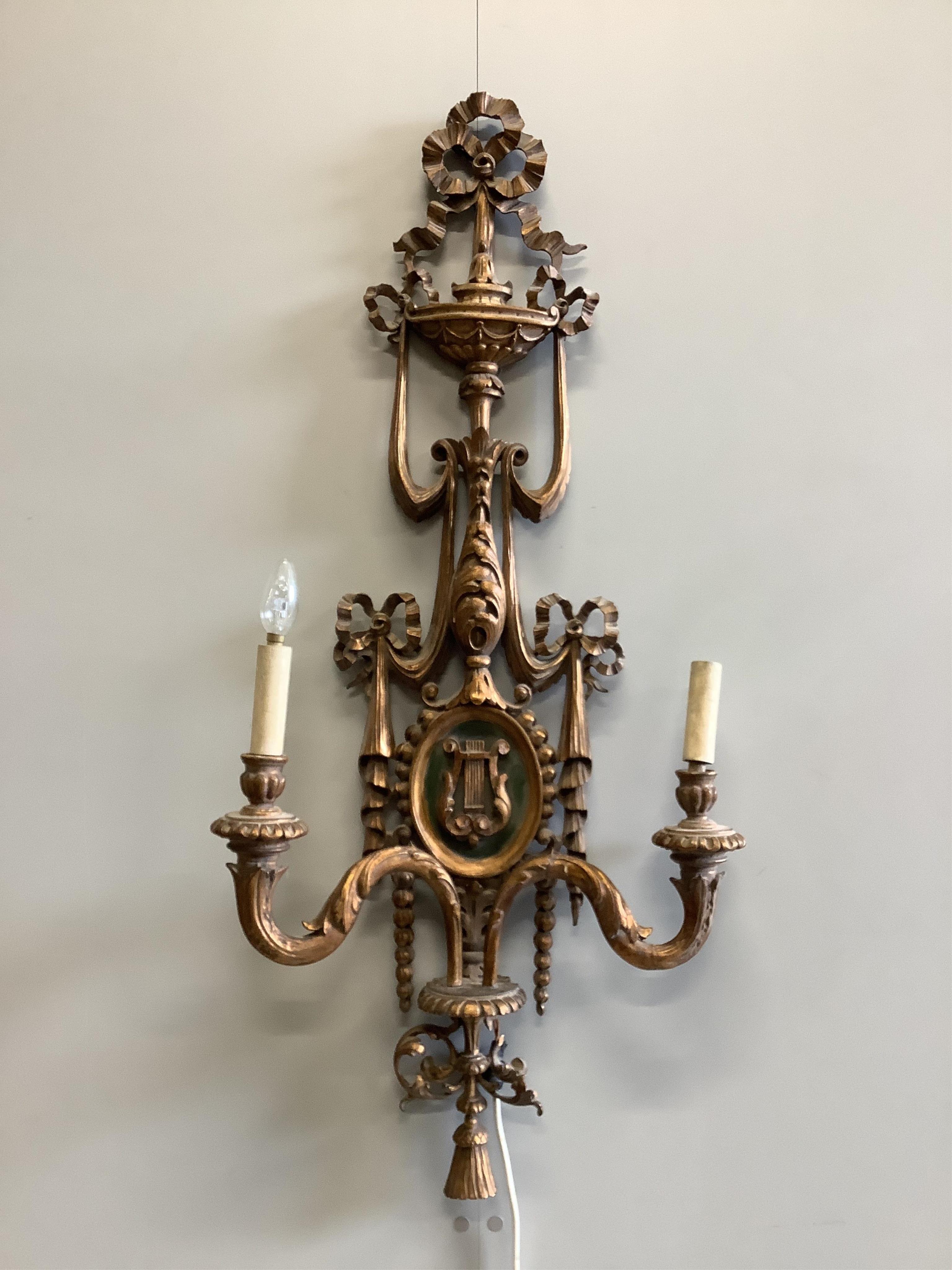 A pair of Louis XV style carved giltwood twin branch wall lights, height 110cm. Condition - fair